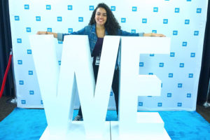 Katherine Perez '19 poses with the large letters "WE"