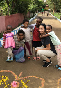 Kayla poses with children. 