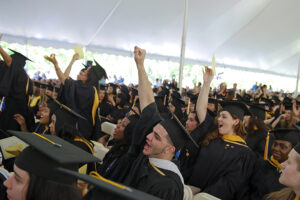 Graduates cheer in the Commencement tent. 
