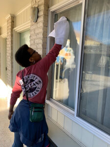 Student cleaning a window.