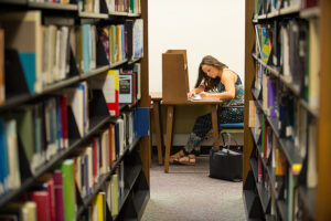 Student writes in the Elizabeth Seton Library. 