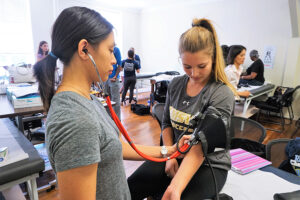 Two student nurses practice.