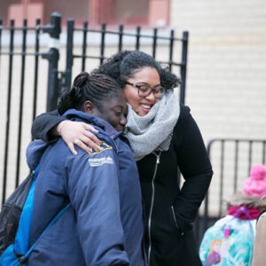 Mallorie Bocachica ’10 hugging a student.