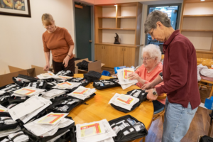 Two volunteers check first-aid kits for quality control