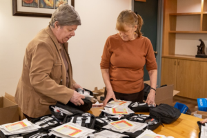 Two volunteers assemble first aid kits