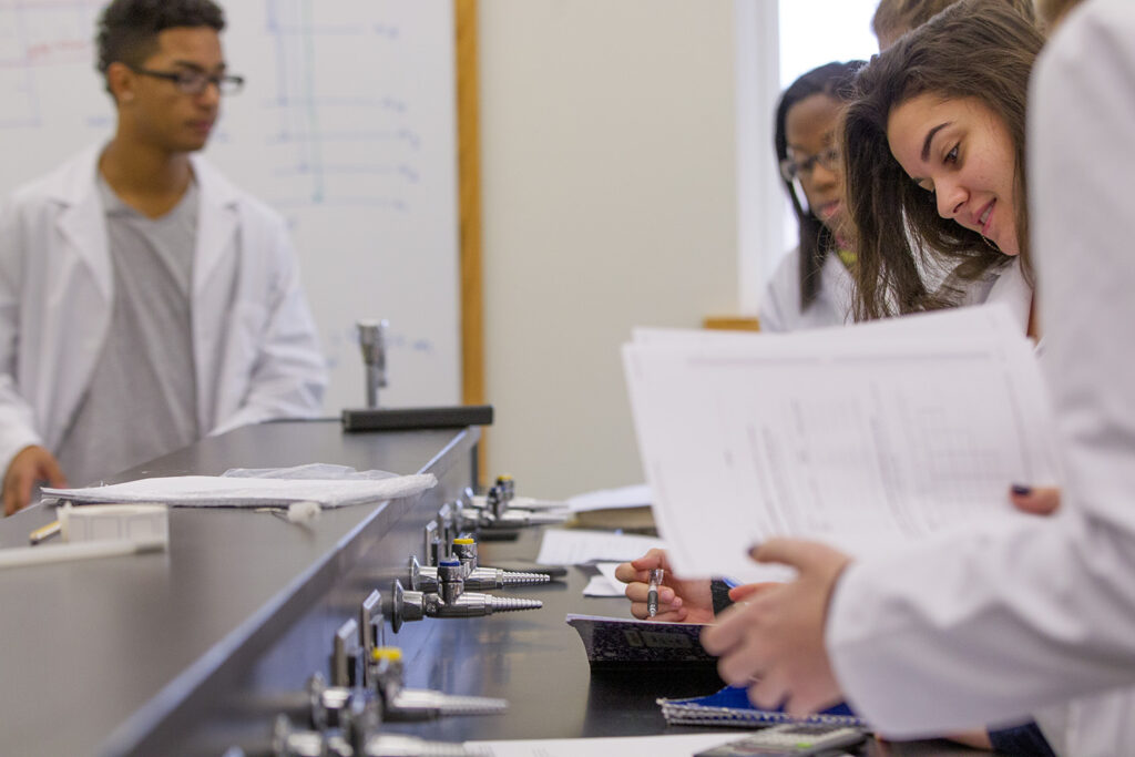 Students compare notes in a science lab.