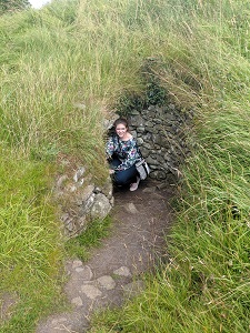 Maire Fox '12 poses outside a passage tomb in Ireland