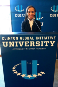 Yafreisy Carrero '10 poses at a podium at the Clinton Global Initiative University.