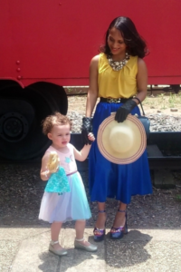 Yafreisy Carrero '10 and her young daughter pose in front of a red train.