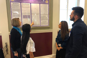 Students and a professor discuss a presentation.