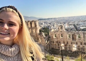 Caitlin Kessel '20 poses with Ancient Greek buildings. 