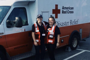 Carly Jenkinson and a colleague next to a Red Cross truck.