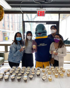 Vinny poses with students and cupcakes.