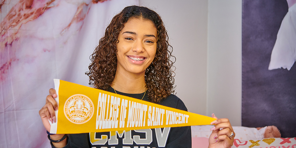 Student holding a College of Mount Saint Vincent pennant.
