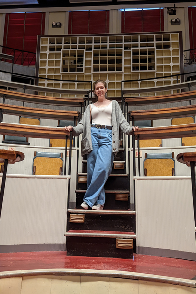 Maire Fox '12 poses among seats in a lecture hall