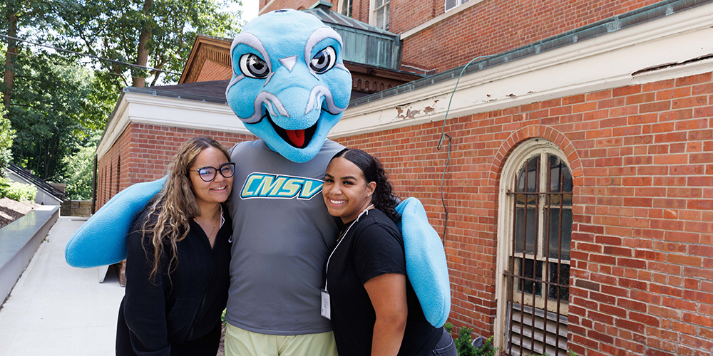 Photo of two students with Vinny the dolphin, the Mount Saint Vincent mascot